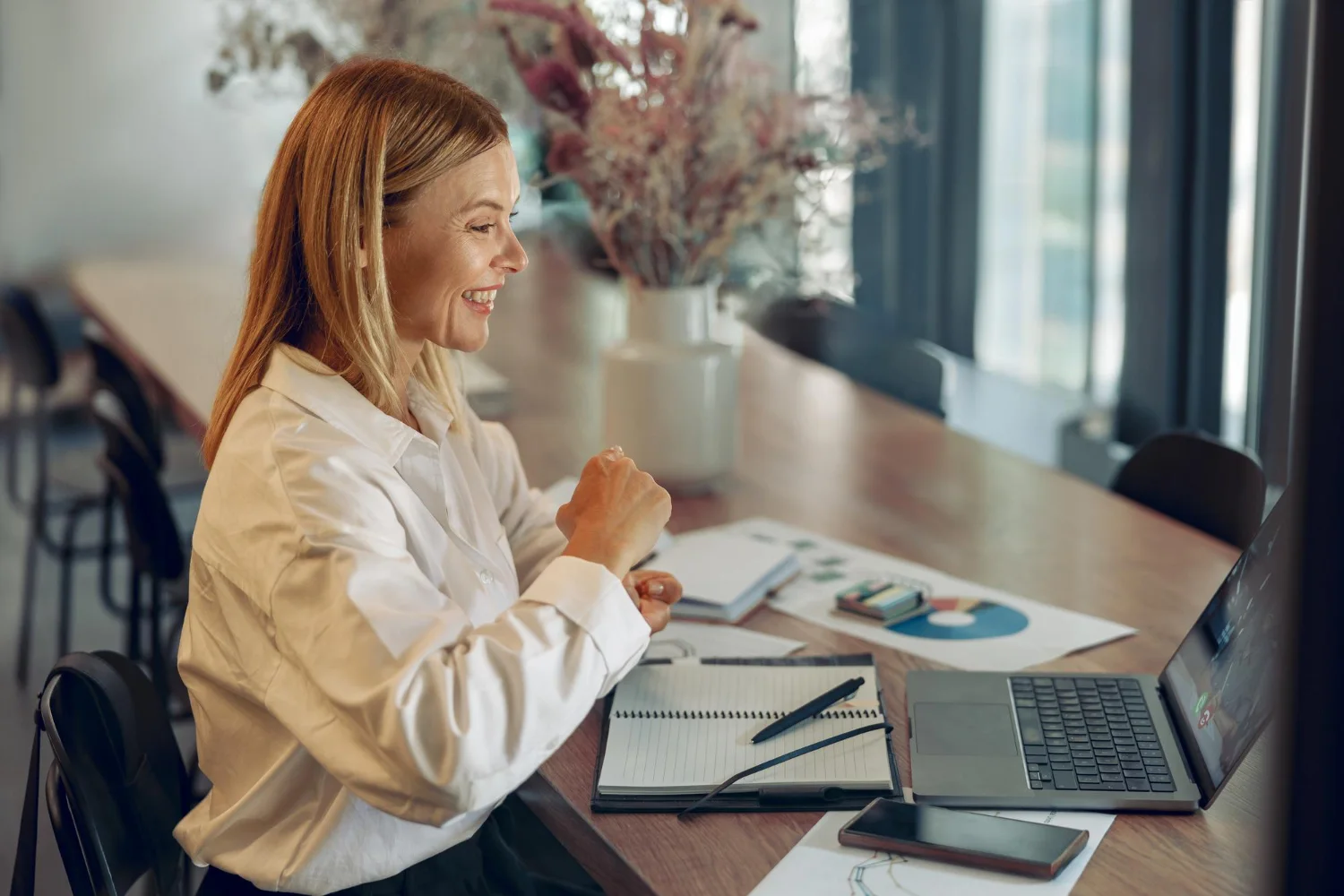 Woman smiling and while a business call